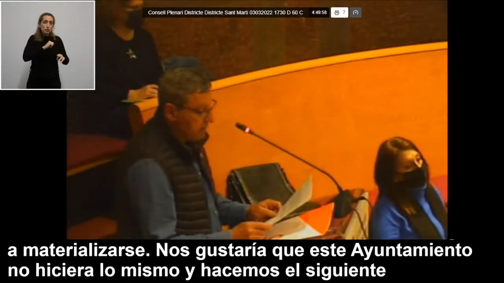 Captura d’un streaming accessible del Consell Plenari del Districte de Sant Martí amb una intervenció a la sala, interpretació en llengua de signes catalana i subtítols en directe.