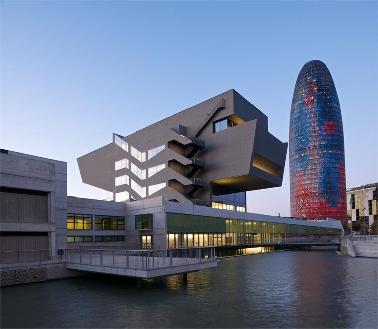 Imatge exterior del DHub, edifici contemporani amb formes geomètriques i grans superfícies de vidre i metall.