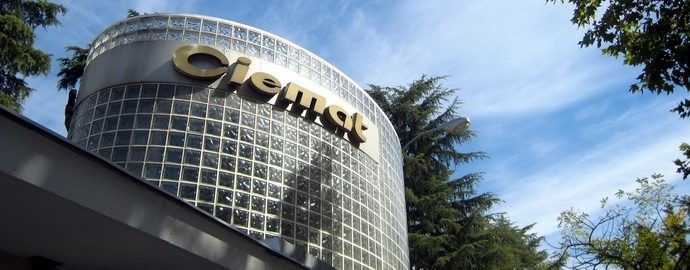 Edifici modern amb façana corba de blocs de vidre i el logotip “Ciemat” a la part superior.